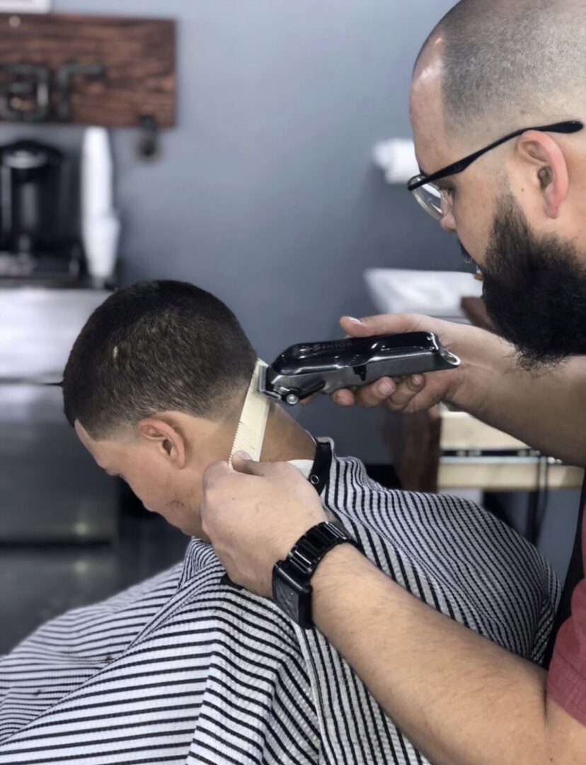 Barber trimming fade haircut with clippers